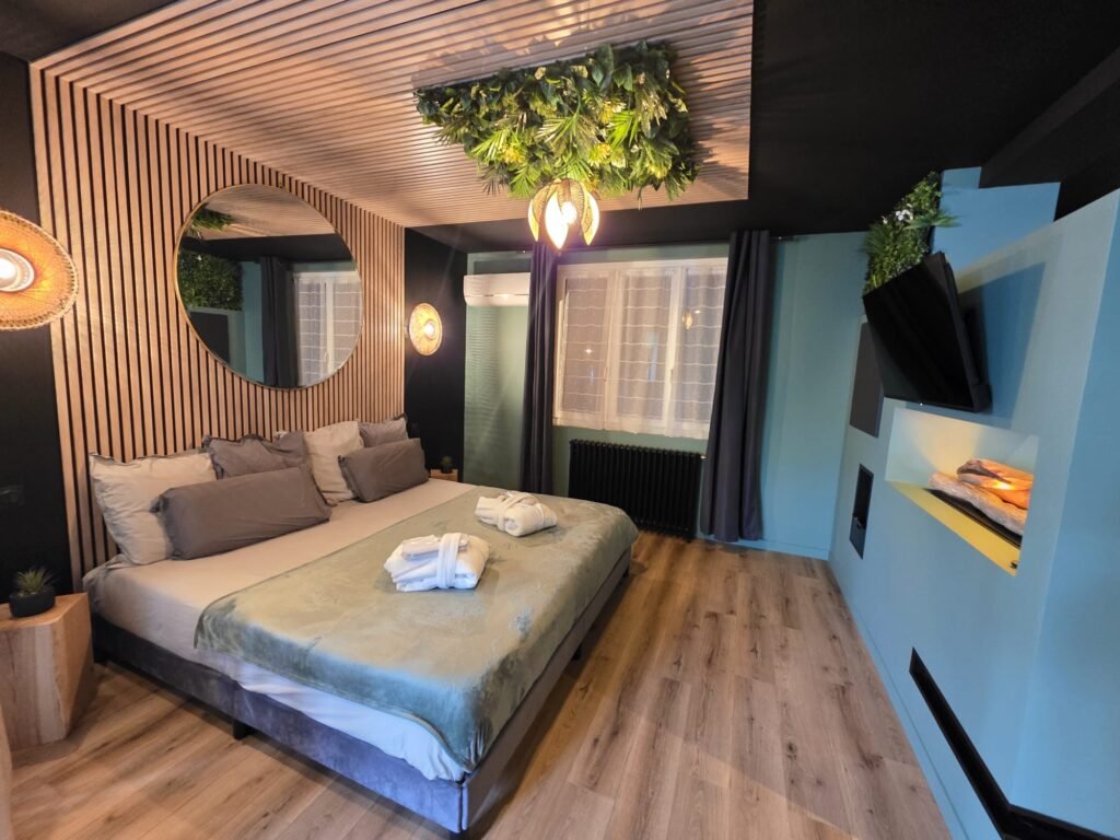 Lit double avec ciel végétal suspendu et lumière naturelle, dans une chambre au design chaleureux et zen