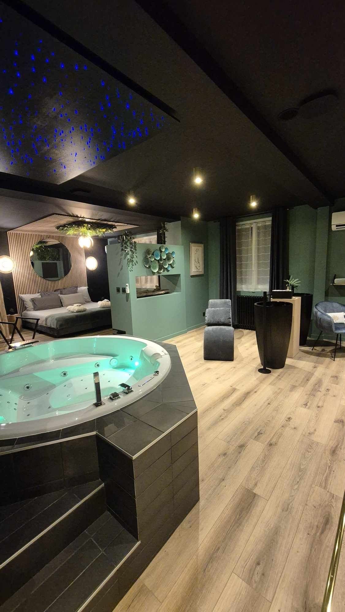 Vue d’ensemble sur la suite Toi & Moi avec jacuzzi au centre, lit double, décoration naturelle et ambiance apaisante